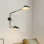 French design long arm wall sconce above a sofa in a styled living room